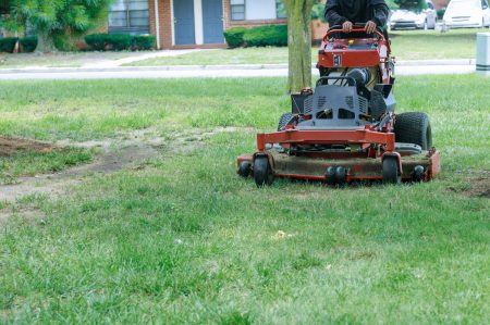 Close up of man using a lawn mower a gardener cutting grass by lawn mower