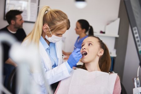 Focused orthodontist using dental mirror