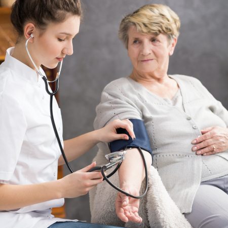 Nurse taking elderly woman's blood pressure